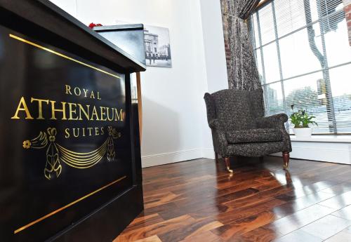 a sign for the royal athenian convention suites in a room with a chair at Royal Athenaeum Suites in Aberdeen