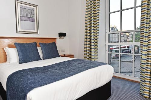 a bedroom with a large bed and a large window at Royal Athenaeum Suites in Aberdeen