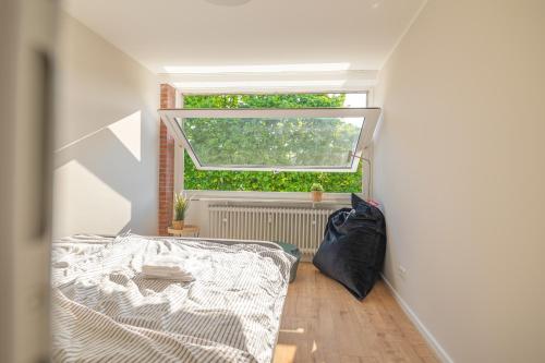 une chambre avec un lit et une fenêtre dans l'établissement Moin Apartment Mit 2 Balkonen u kostenlosen Parkmöglichkeiten, à Bremerhaven