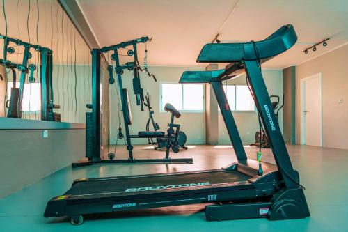 a gym with a treadmill and two exercise bikes at Hotel Apartamento Foz Atlantida in Monte Gordo