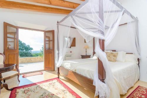 a bedroom with a bed with a canopy at Finca Son Punta in Felanitx