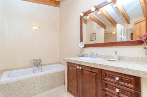 a bathroom with a tub and a sink and a mirror at Finca Son Punta in Felanitx