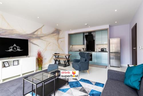een woonkamer met een bank en een tv en een keuken bij Your Apartment Awaits! in Gillingham