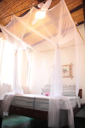 
a bed room with a bed with a canopy over it at Bali Suites Itamambuca in Ubatuba
