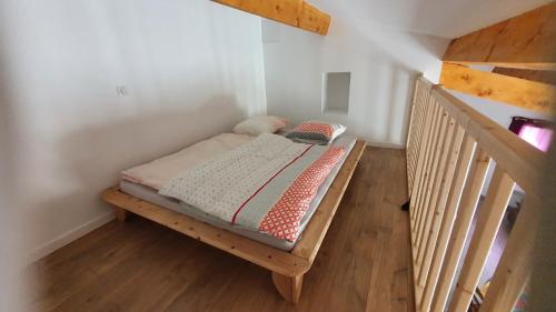 1 cama en una plataforma de madera en una habitación en Le Tras Castel, 4 places jardin piscine, en Saint-Jean-de-Buèges