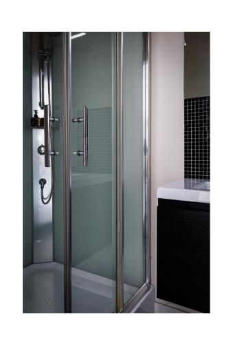 a shower with a glass door in a bathroom at Central Perk Apartments-Antwerp in Antwerp