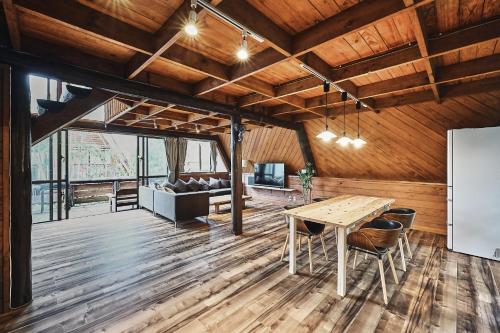 a dining room with a table and a couch at LOGIN OKINAWA -nature- in Onna