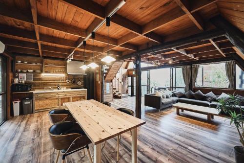 a kitchen and living room with a wooden table at LOGIN OKINAWA -nature- in Onna
