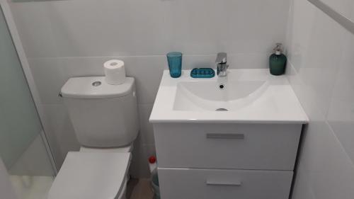 a white bathroom with a toilet and a sink at HAPPY HoMe For You in Lunel