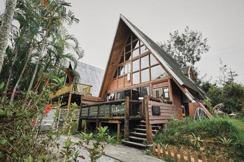 a large wooden house with a staircase leading up to it at LOGIN OKINAWA -nature- in Onna