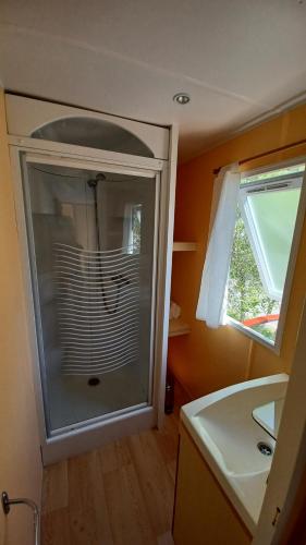 uma casa de banho com uma cabina de duche em vidro e um lavatório. em Cloud Nine em Pataias