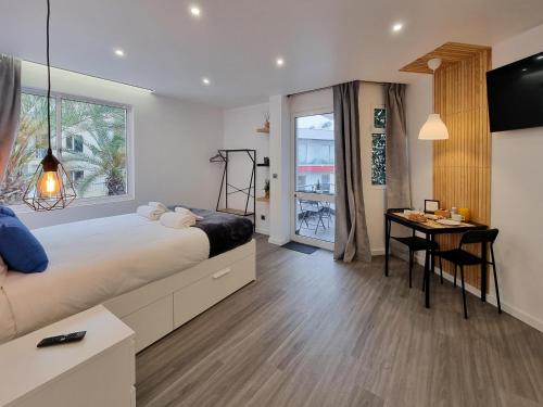 um quarto com uma cama, uma mesa e uma janela em The Jolie Apartments - by the Ocean em Porto Moniz