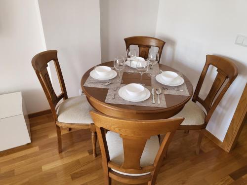 a dining room table with plates and glasses on it at Piso céntrico 2 habitaciones a escasos metros de Maria Pita in A Coruña