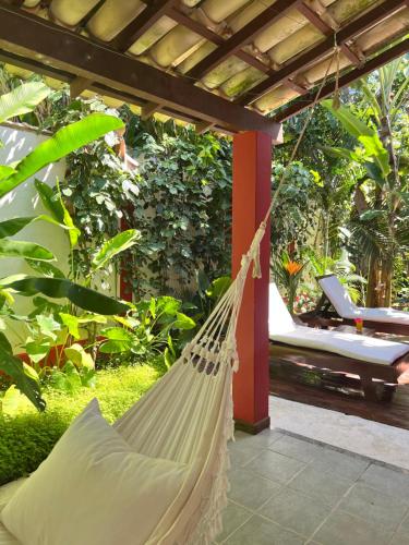 a hammock hanging from a pergola on a patio at Casa da Beatriz in Trancoso