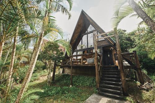 a bamboo house in a forest with palm trees at LOGIN OKINAWA -monotone- in Onna