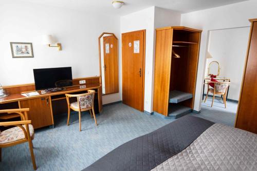 a hotel room with a bed and a desk with a computer at Garni Hotel Maselheimer Hof in Maselheim