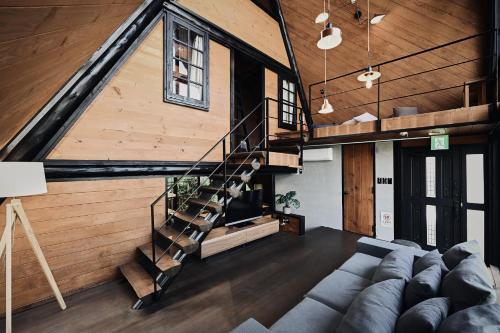 a living room with a couch and a staircase at LOGIN OKINAWA -monotone- in Onna