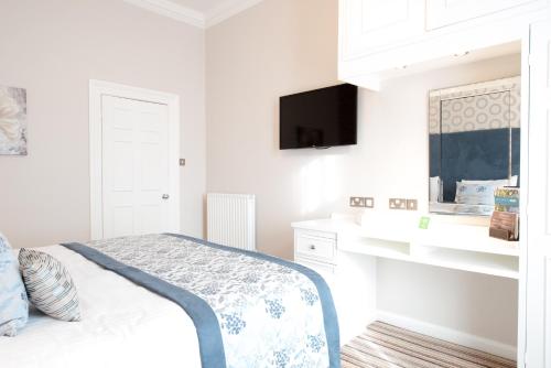 a white bedroom with a bed and a flat screen tv at Burlington Hotel, BW Premier Collection by Best Western in Folkestone