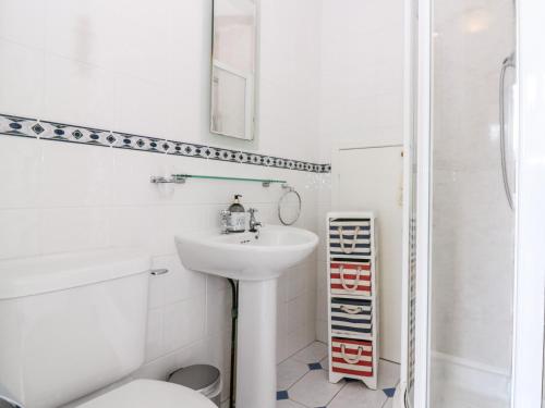 a white bathroom with a sink and a toilet at 16 Westgate South in Anstruther