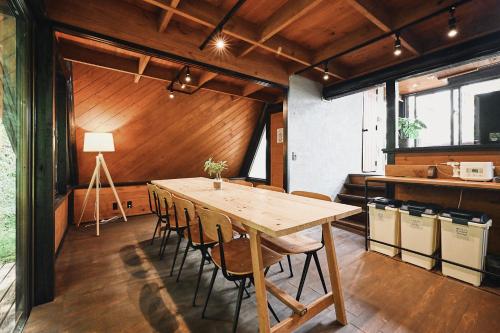 a dining room with a wooden table and chairs at LOGIN OKINAWA -monotone- in Onna