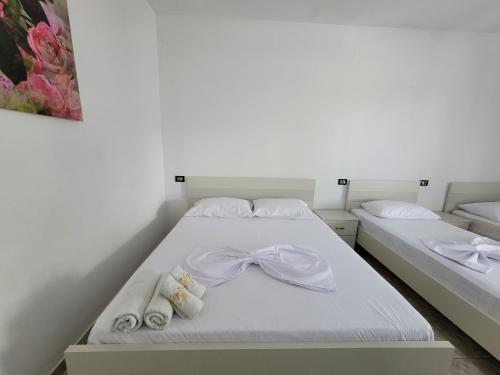 a white bed with towels and bows on it at Spahiu Guesthouse in Ksamil