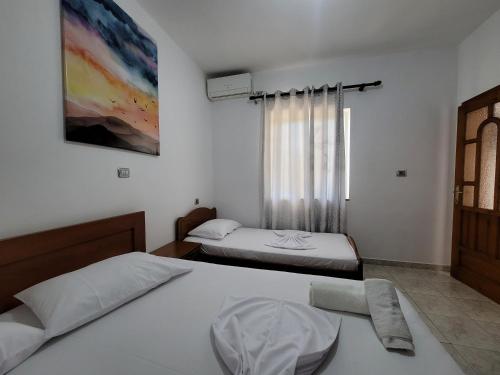 a bedroom with two beds and a window at Spahiu Guesthouse in Ksamil