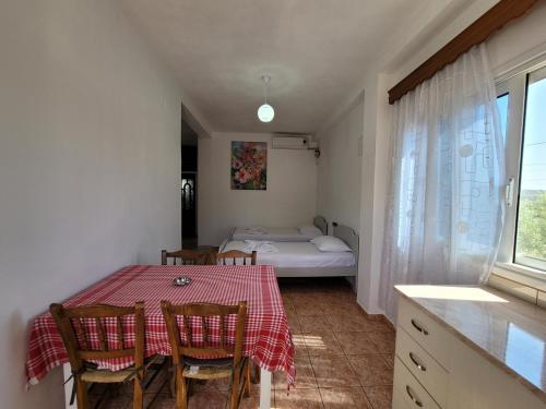 a room with a table and chairs and a bed at Spahiu Guesthouse in Ksamil