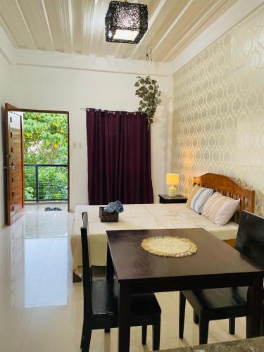 a bedroom with a bed and a table and a dining room at Sto Niño Residences Lucena City in Lucena
