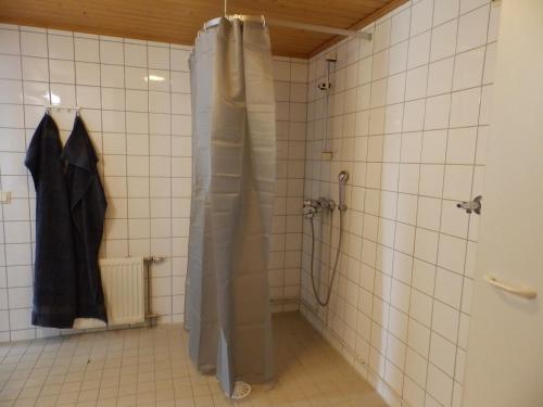 a shower in a bathroom with a tiled wall at Gasthouse Oulu in Oulu