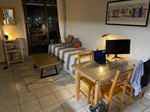 een woonkamer met een tafel en een laptop. bij T2 sur Marina avec vue spectaculaire in Le Barcarès