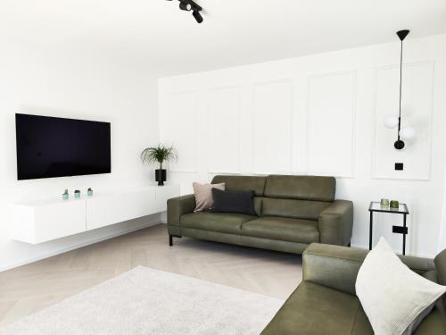 a living room with a couch and a tv at Ferienhaus Stadtblick in Bad Marienberg