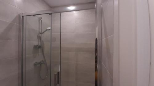 een douche met een glazen deur in de badkamer bij HAPPY HoMe For You in Lunel