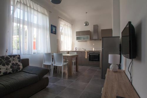 Apartments Svilan في تروغير: غرفة معيشة مع أريكة وغرفة طعام