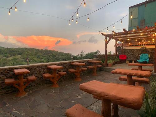 a group of wooden benches and tables on a patio at Cabinas Vista Al Golfo in Monteverde Costa Rica