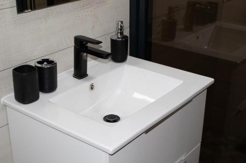 ein Waschbecken mit einem schwarzen Wasserhahn darauf in der Unterkunft Immaculate 2-Bed Cottage in Marloth Park in Marloth Park