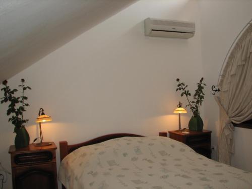 ハイドゥソボスローにあるHajdu Apartman 1.のベッドルーム1室(ベッド1台、ナイトスタンドのランプ2つ付)