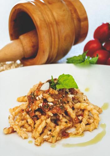 a plate of pasta on a white plate with a cup at Sunset in Trapani