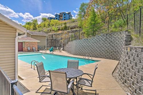 a swimming pool with a table and chairs next to a house at Modern Condo with Deck about 7 Mi To Branson Landing! in Branson