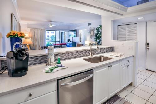 a kitchen with white cabinets and a sink at COQUINA 3C in Sanibel