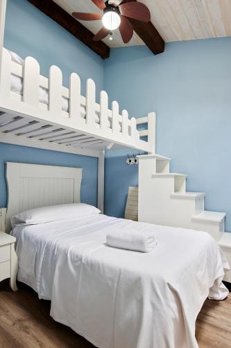 a bedroom with a white bed and white stairs at Apartamento Bari in Plasencia