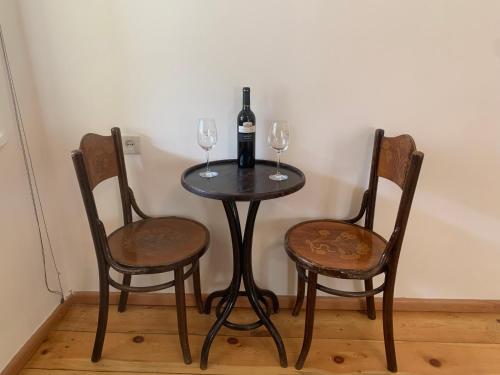 - une table avec 2 chaises et une bouteille de vin dans l'établissement Hotel Lemi, à Mestia