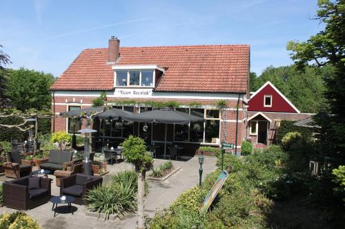 a building with a restaurant with chairs and an umbrella at Boutique Hotel Nieuw Beusink in Winterswijk