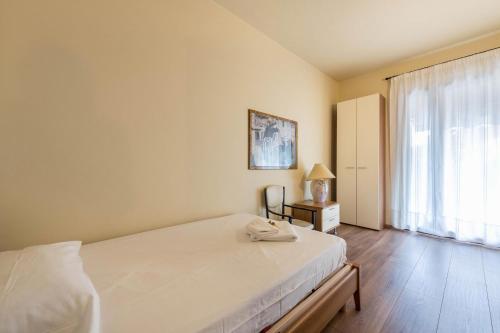 a bedroom with a white bed and a window at Casa Vacanze Matisse in Toscolano Maderno