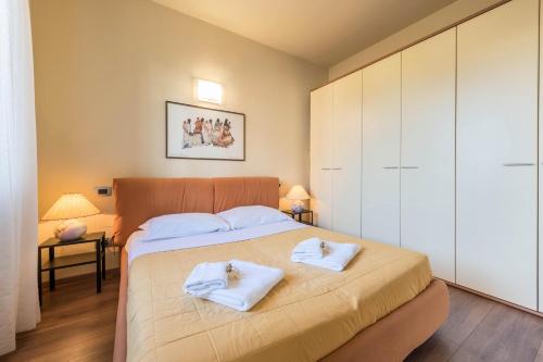a bedroom with a bed with two white towels at Casa Vacanze Matisse in Toscolano Maderno