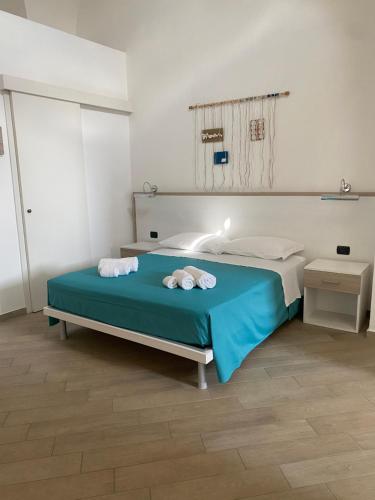 1 dormitorio con 1 cama con toallas en B&B Cadorna, en Leverano