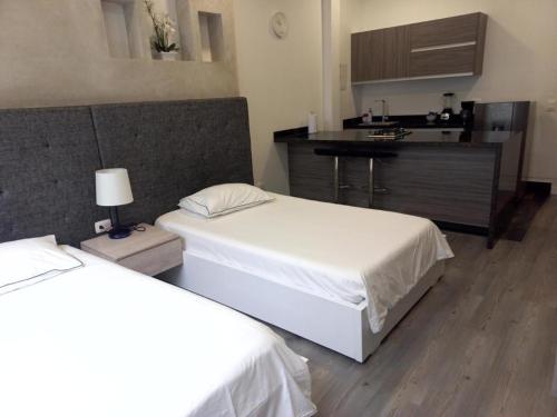ein Schlafzimmer mit 2 Betten und eine Küche mit einer Theke in der Unterkunft Edificio Lotus Loft in Cali