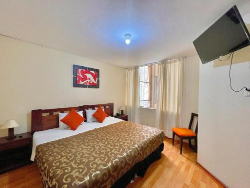 a hotel room with a bed and a flat screen tv at Mandala Rooms & Services in Arequipa