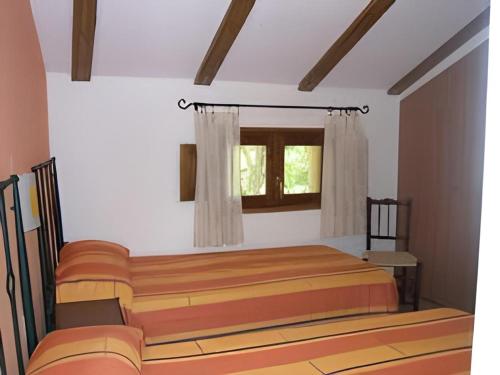 - une chambre avec 2 lits et une fenêtre dans l'établissement Casa rural Teresa la Cuca, à Jérica
