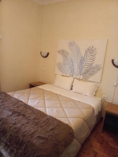 a bedroom with a large bed with two pillows at Residencial Cabeça da Velha in Catraia do Bugalho