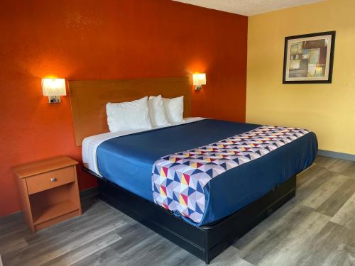 um quarto de hotel com uma cama com uma colcha azul em Economy Inn Hot Springs em Hot Springs